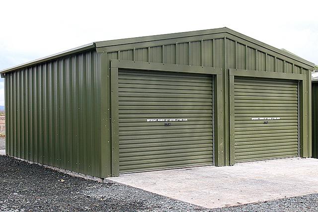 A green building with two closed roller doors